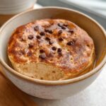 A single baked protein pancake bowl topped with chocolate chips and drizzled with syrup.