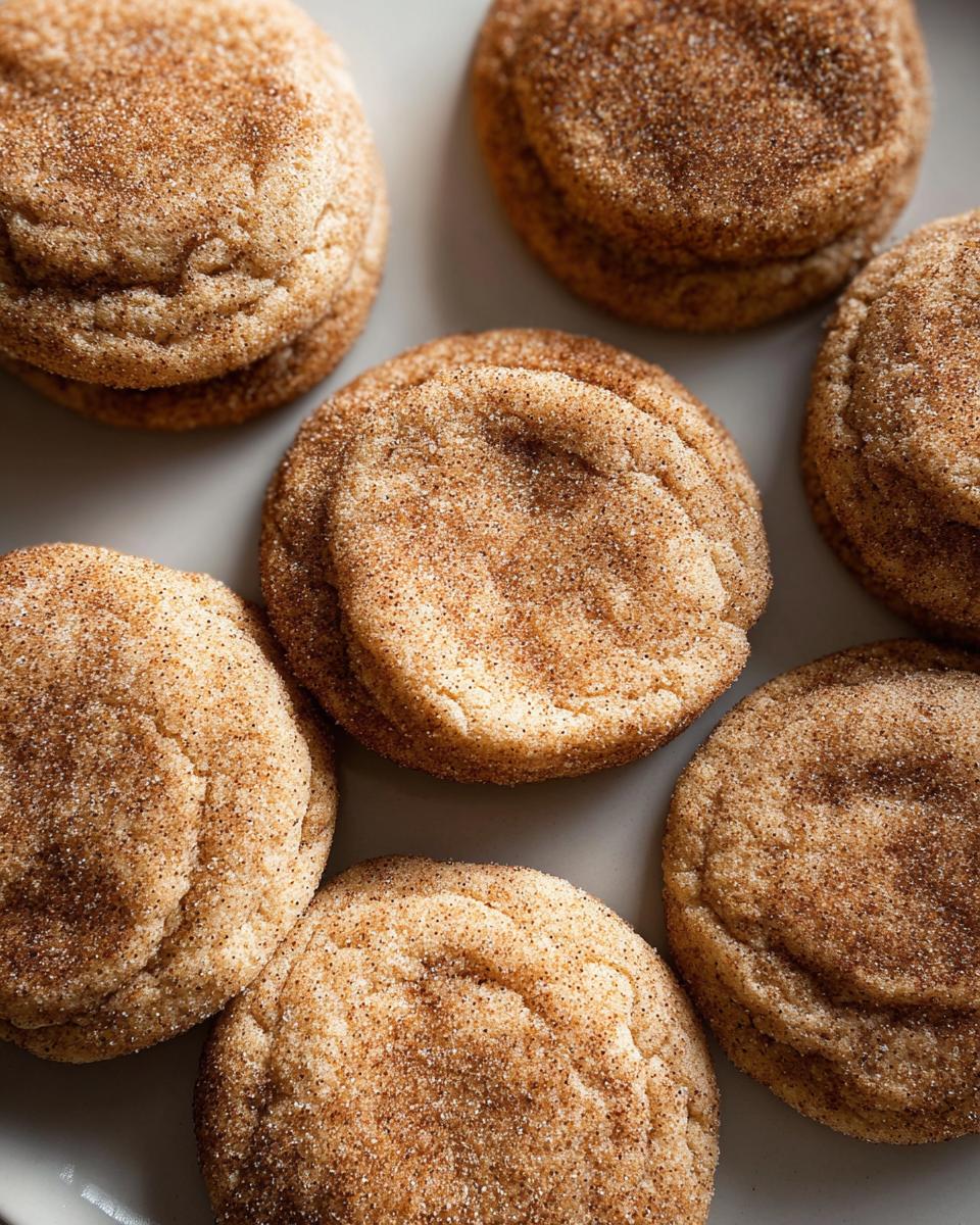 Close-up of several chewy churro cookies generously coated in cinnamon sugar.