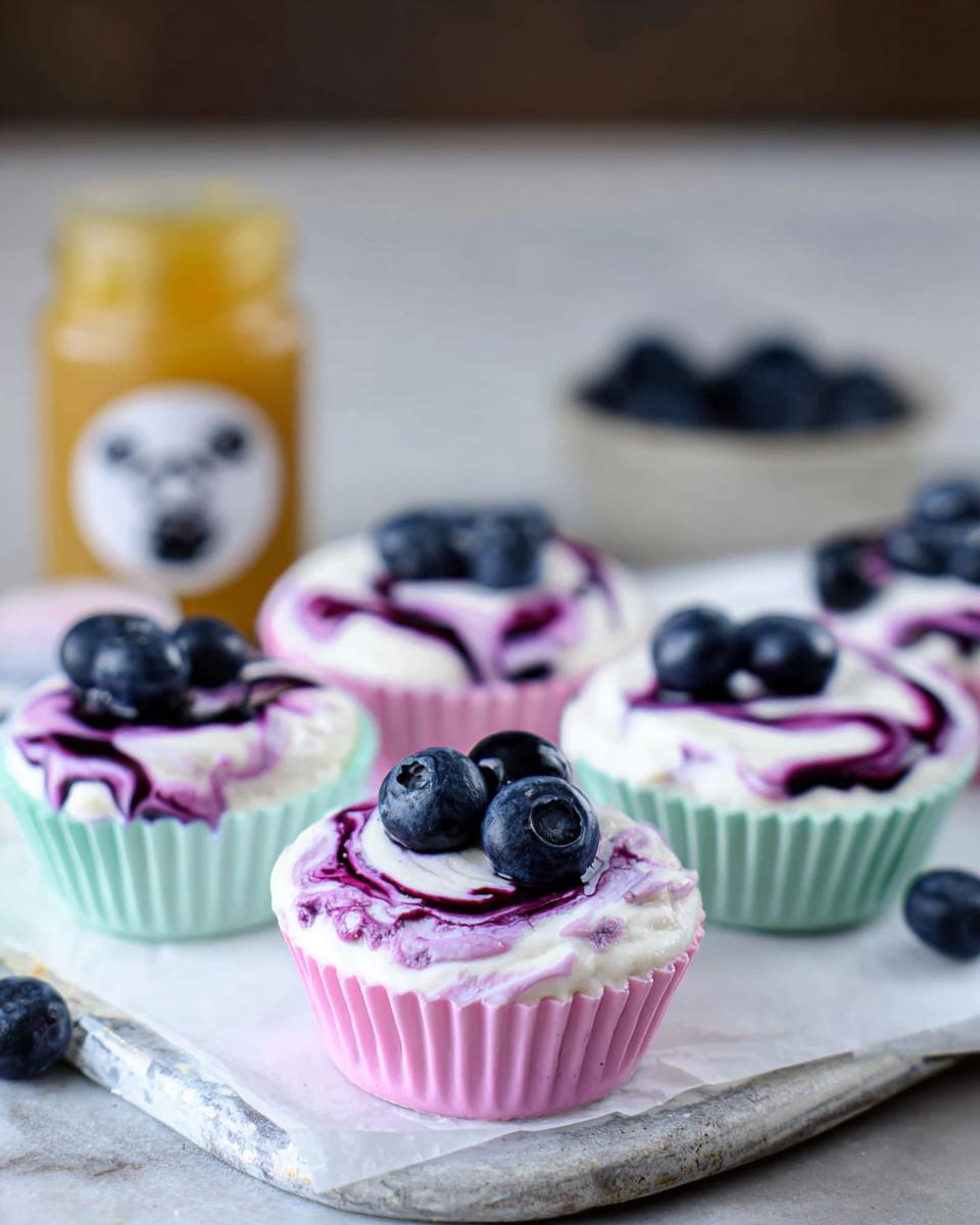 Close-up of Easy Blueberry Swirl Yogurt Bites topped with fresh blueberries and blueberry swirl.