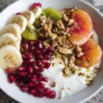 A vibrant and delicious Easy Yogurt Granola Bowl topped with banana, kiwi, orange slices, pomegranate seeds, and granola.