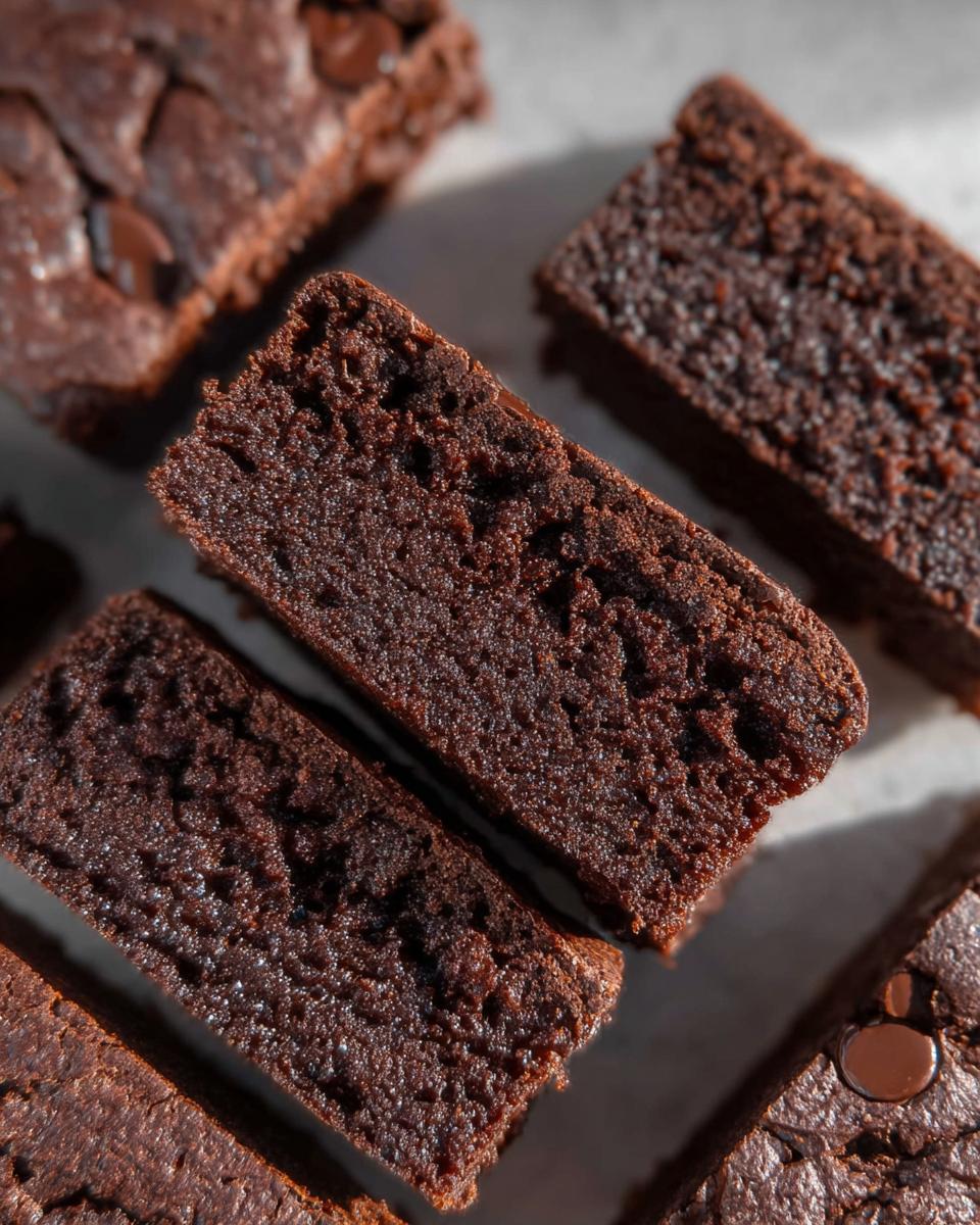 Close-up of rich, dark chocolate Greek Yogurt Brownies with visible chocolate chips.