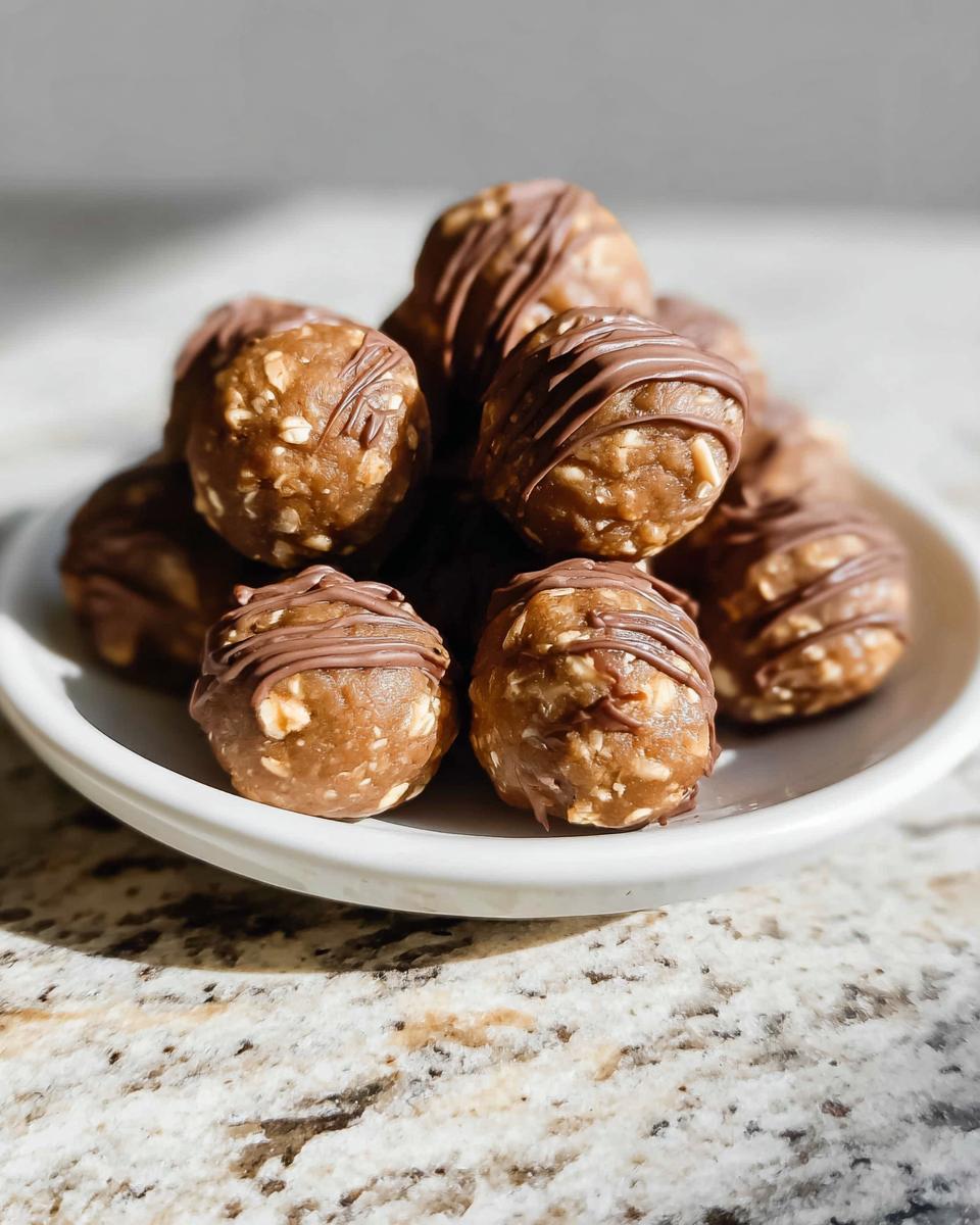 A pile of delicious No-Bake Chocolate Peanut Butter Protein Balls drizzled with chocolate on a white plate.